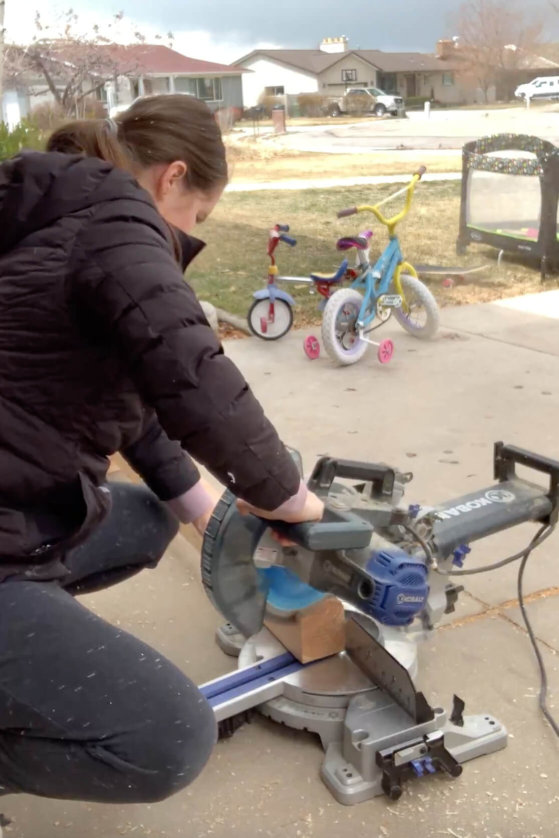 Using a miter saw to cut an angle on table legs for a DIY table.